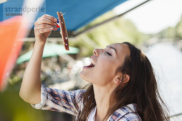 Niederlande  Amsterdam  junge Frau isst Matjeshering