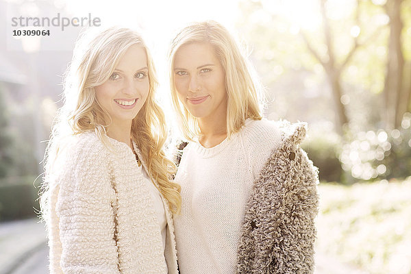 Portrait von zwei lächelnden blonden Frauen im Gegenlicht