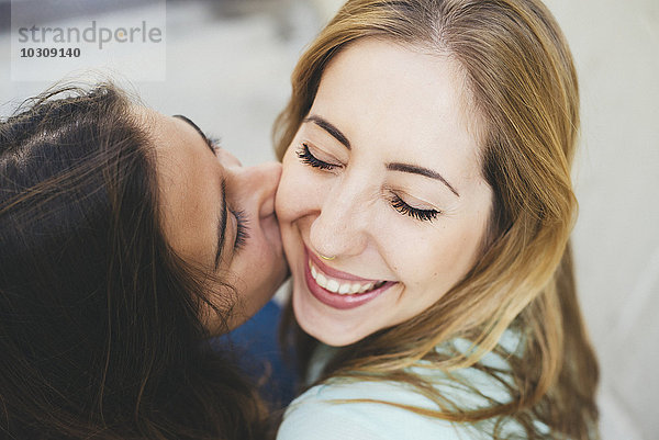 Mädchen küsst junge Frau auf die Wange
