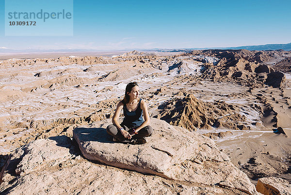 Chile  Atacama-Wüste  Frau auf einer Klippe sitzend
