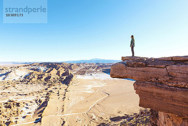 Chile  Atacama-Wüste  Frau steht auf einer Klippe und schaut auf die Aussicht.