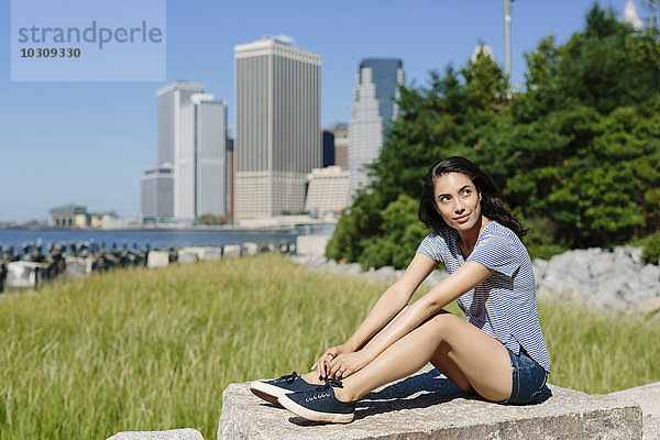 USA  New York City  Porträt einer jungen Frau  die sich in der Sonne entspannt