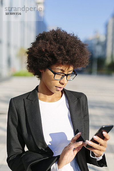USA  New York City  Geschäftsfrau beim Blick auf ihr Smartphone