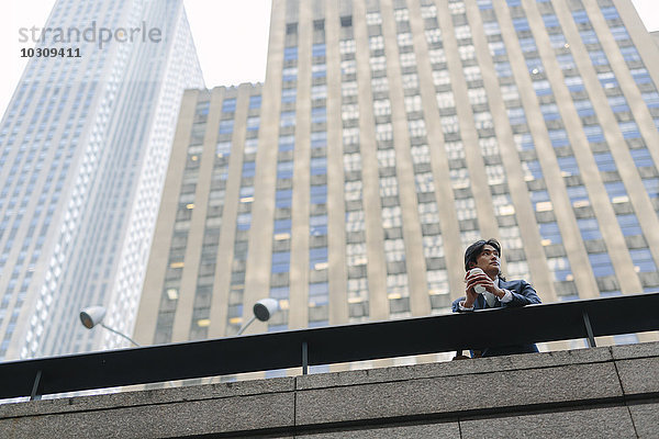 USA  New York City  Geschäftsmann vor Wolkenkratzern in Manhattan