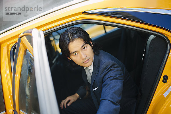 USA  New York City  Porträt eines Geschäftsmannes beim Einsteigen in ein Taxi