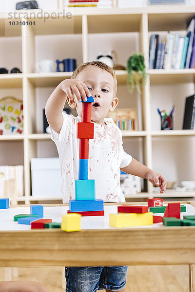 Porträt des kleinen Jungen beim Spielen mit Bausteinen