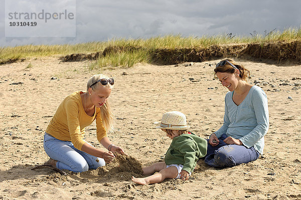 Frankreich  Britannien  Sainte-Anne-la-Palud  Mutter und ihre beiden Töchter auf der Stranddüne sitzend