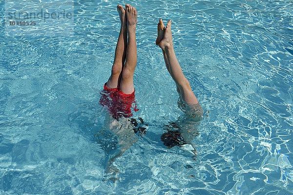 Teenager Junge und Mädchen beim Handstand im Schwimmbad