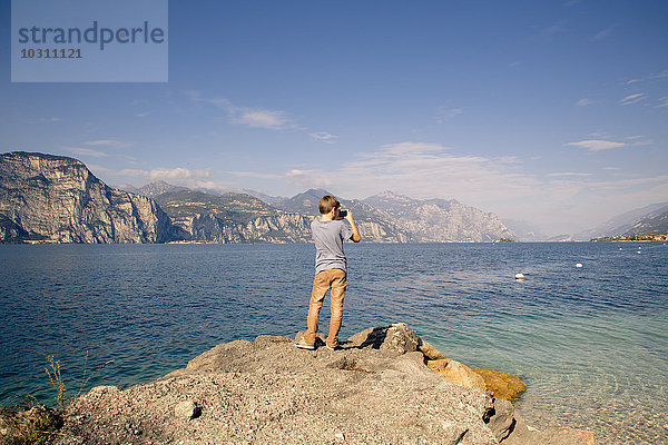 Italien  Veneto  Brenzone sul Garda  Junge fotografiert mit Smartphone
