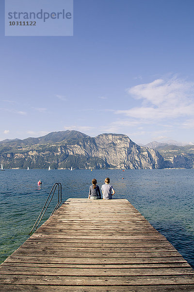 Italien  Venetien  Malcesine  Bordell und Schwester am Steg sitzend