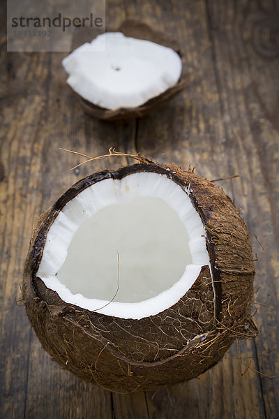 Geöffnete frische Kokosnuss auf Holz