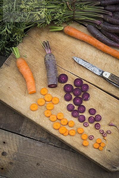 Gehackte Purple Haze und gelbe Karotte auf Holzbrettchen