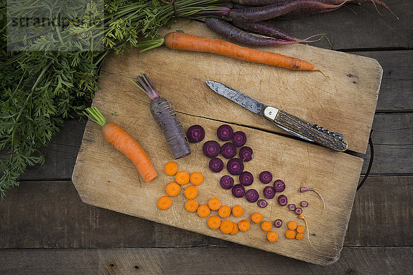 Gehackte Purple Haze und gelbe Karotte auf Holzbrettchen