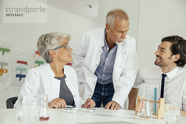 Drei Wissenschaftler sprechen im Labor
