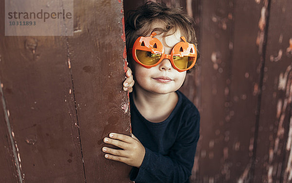 Porträt eines kleinen Mädchens mit Halloween-Brille in Kürbisform