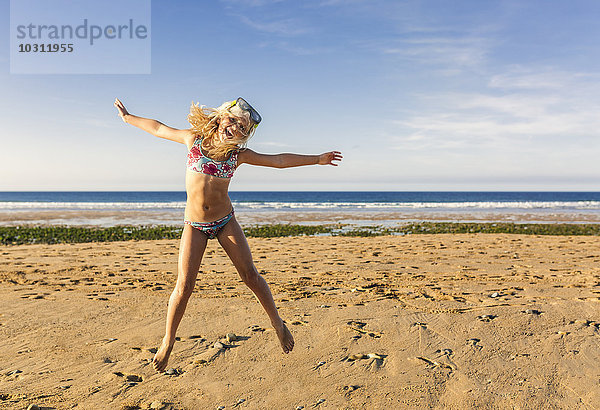 Spanien  Colunga  kleines Mädchen mit Sprungmaske am Strand