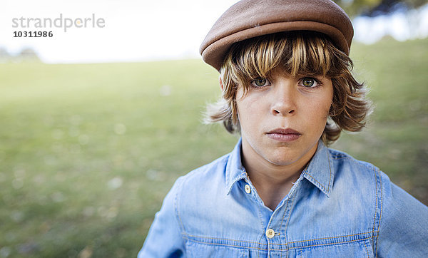 Porträt eines ernsthaft aussehenden blonden Jungen mit Mütze