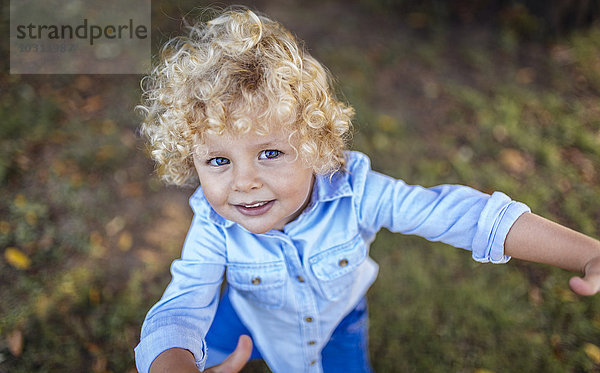 Porträt eines lächelnden blonden kleinen Jungen  der zur Kamera schaut.