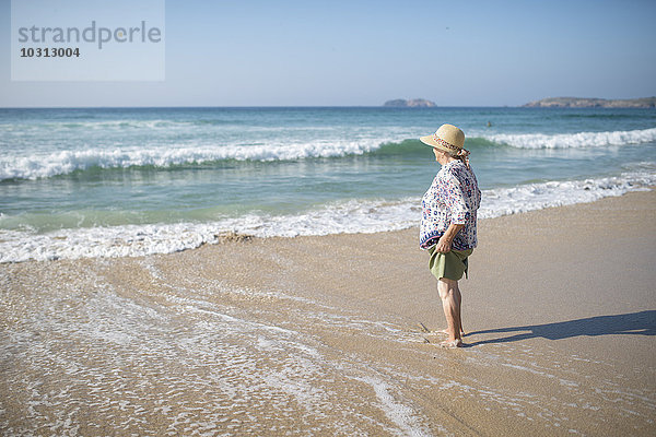 Spanien  Ferrol  Seniorin am Strand stehend mit Blick auf die Ferne