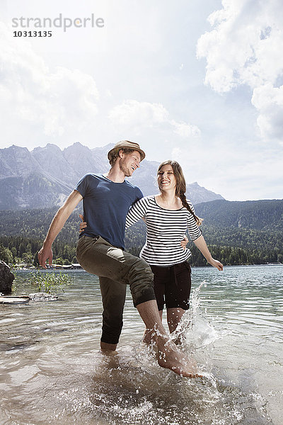 Deutschland  Bayern  Eibsee  glückliches Pärchen beim Planschen im Wasser