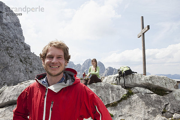 Deutschland  Bayern  Osterfelderkopf  Porträt eines lächelnden Wanderers mit Frau am Gipfelkreuz