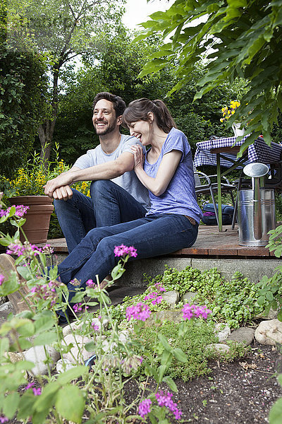 Glückliches Paar sitzt auf der Gartenterrasse