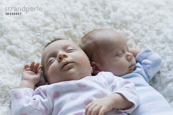 Porträt eines schlafenden neugeborenen Mädchens  das neben seinem Zwillingsbruder liegt.