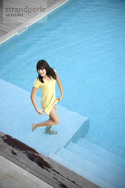 Glückliche junge Frau im Schwimmbad stehend