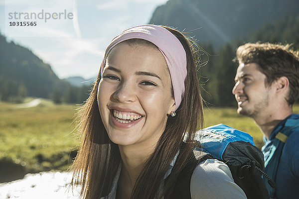 Österreich  Tirol  Tannheimer Tal  Portrait einer glücklichen jungen Frau mit Haarband