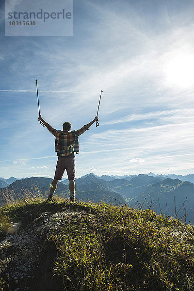 Österreich  Tirol  Tannheimer Tal  junger Mann jubelt auf den Berggipfel