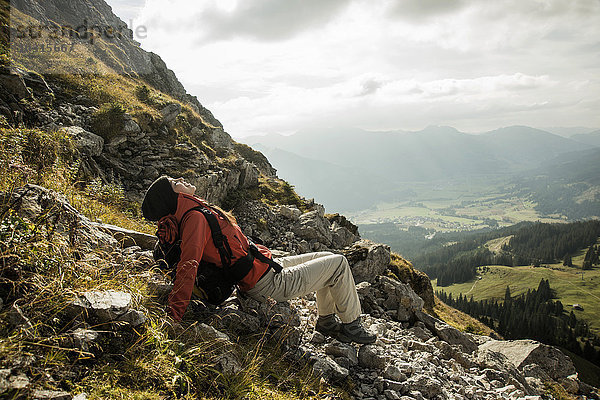 Österreich  Tirol  Tannheimer Tal  junge Wanderin beim Ausruhen in den Bergen