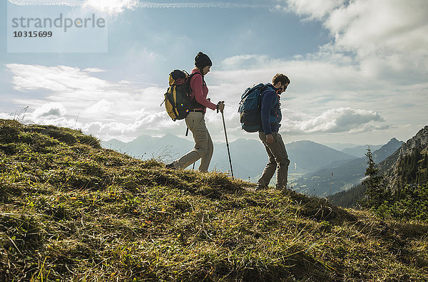 Österreich  Tirol  Tannheimer Tal  junges Paar beim Wandern auf Almen