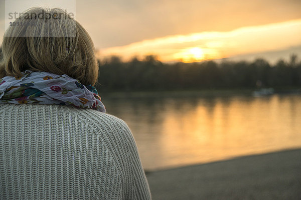 Seniorin bei Sonnenuntergang  Rückansicht