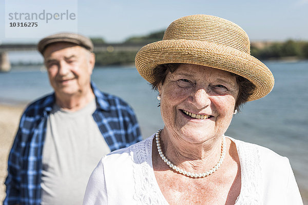 Deutschland  Ludwigshafen  Porträt der lächelnden Seniorin mit ihrem Mann im Hintergrund