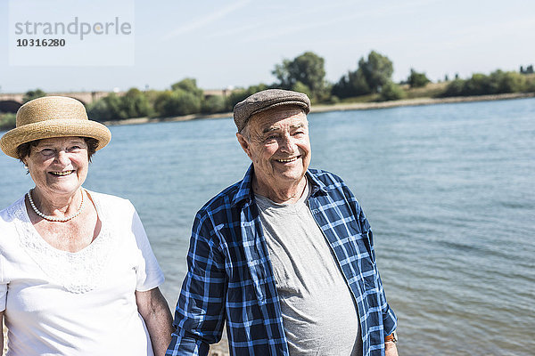 Deutschland  Ludwigshafen  Porträt eines glücklichen Seniorenpaares am Flussufer