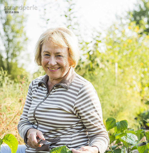 Porträt der lächelnden Seniorin im Garten