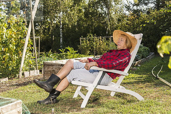 Seniorin entspannt sich von der Gartenarbeit