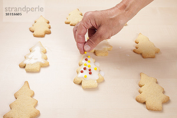 Frau legt Unvergleichliches auf Weihnachtsbaumkekse