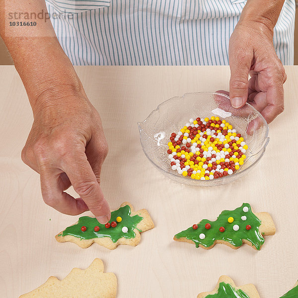 Frau legt Unvergleichliches auf Weihnachtsbaumkekse