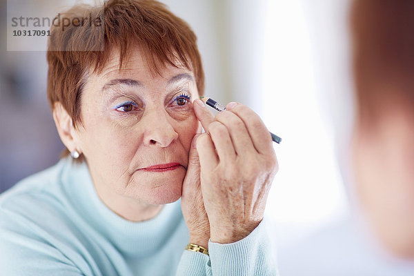 Seniorin beim Schminken