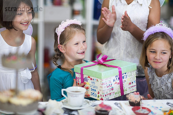Mädchen erhält Geschenk auf einer Geburtstagsfeier