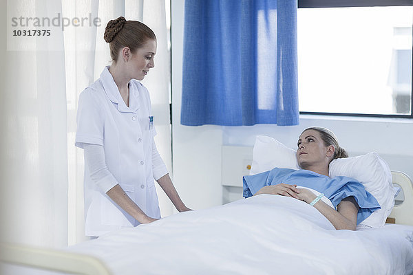 Krankenschwester hilft Patientin im Krankenhaus