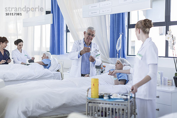 Arzt und Krankenschwester im Krankenbett eines schwerkranken Patienten im Krankenhaus