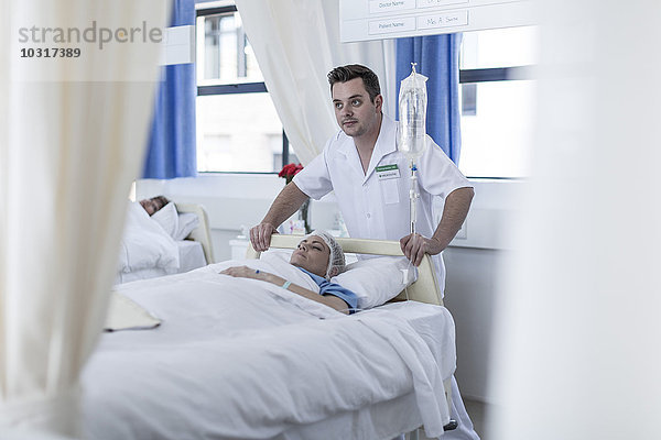 Krankenschwestern bewegenden Patienten liegend im Bett