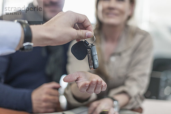 Autohändler übergibt Schlüssel an den Kunden