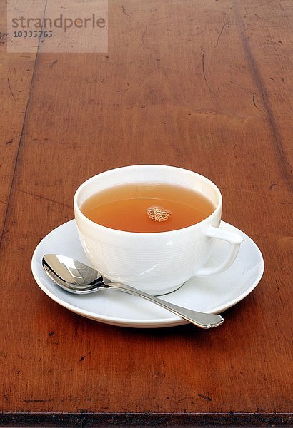 Eine Tasse mit Tee steht auf einem Tisch
