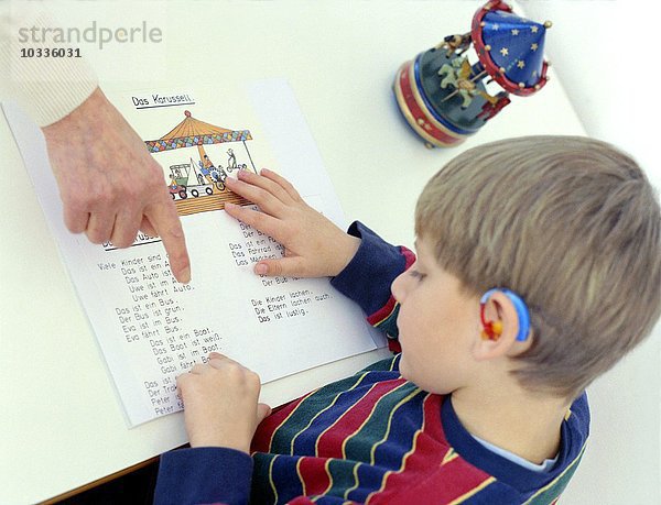 Gehörloser Junge im Vorschulalter liest Die Hörgeschädigtenschule Kreisverkehr Schwäbisch Gmünd