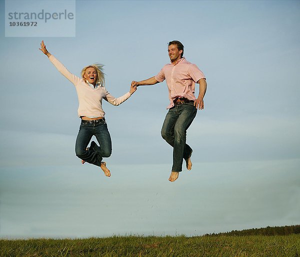 Glückliches Paar springt in die Luft