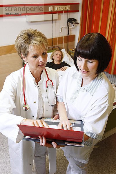 Arzt und Krankenschwester sprechen über eine Patientin in einem Krankenhaus