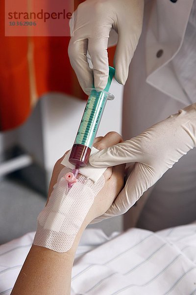 Krankenschwester bei der Entnahme einer Blutprobe von einem Patienten in einem Krankenhaus